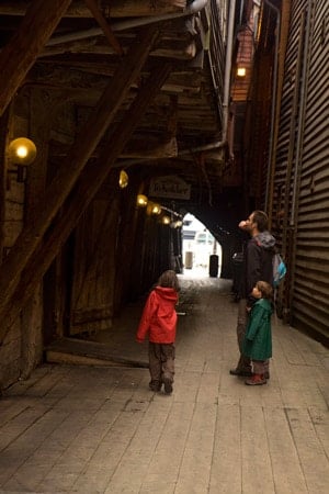 touristes-dans-ruelle-entre-maison-de-quai-bryggen-classé-à-Unesco-Bergen-Norvège